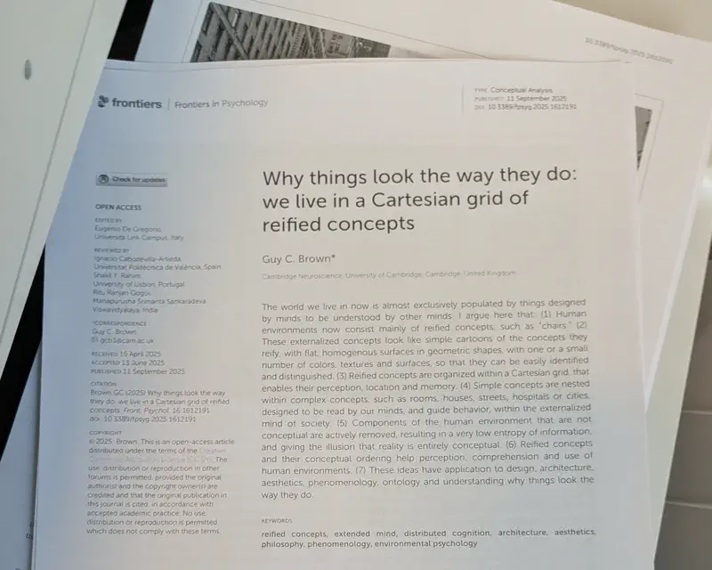 The paper “Why things look the way they do: we live in a Cartesian grid of reified concepts” by Guy C Brown in a pile on a copy machine.